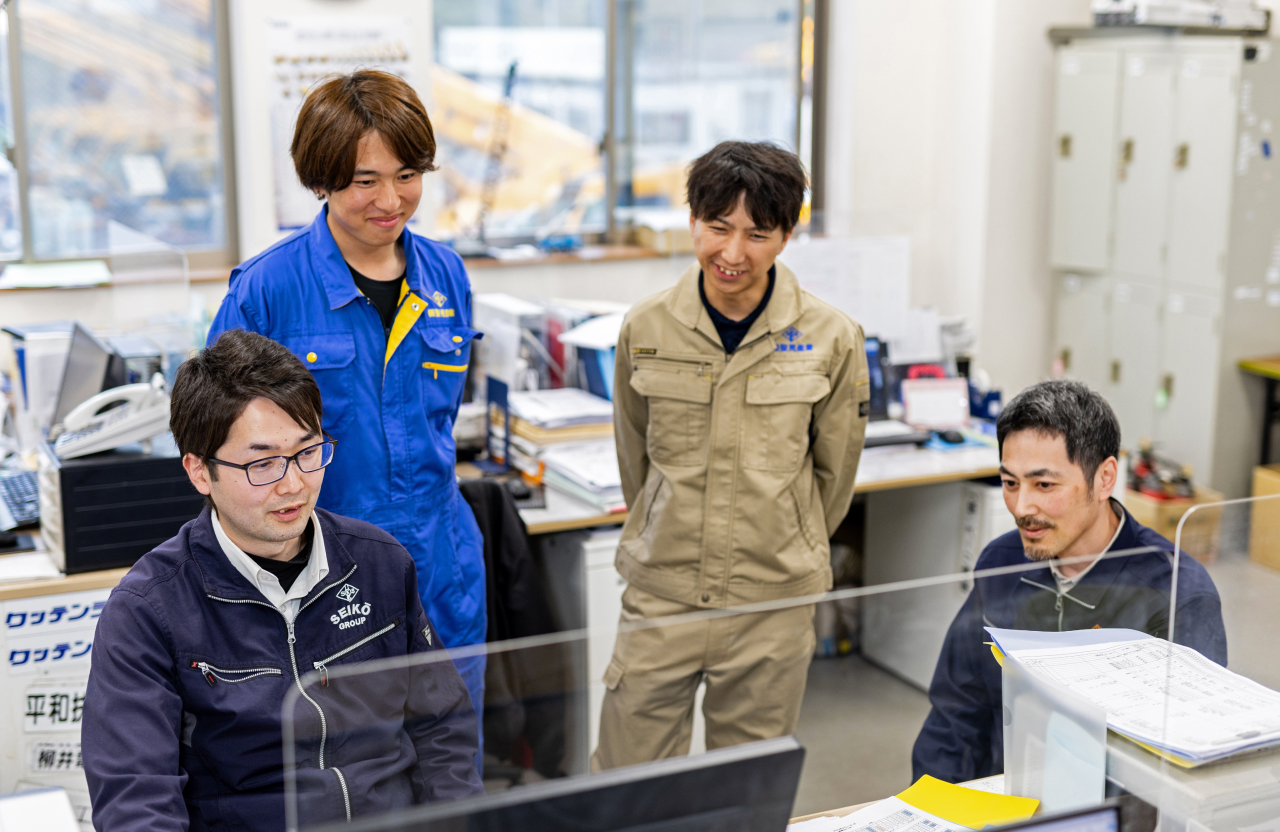 事務所で先輩社員が優しく指導してる風景